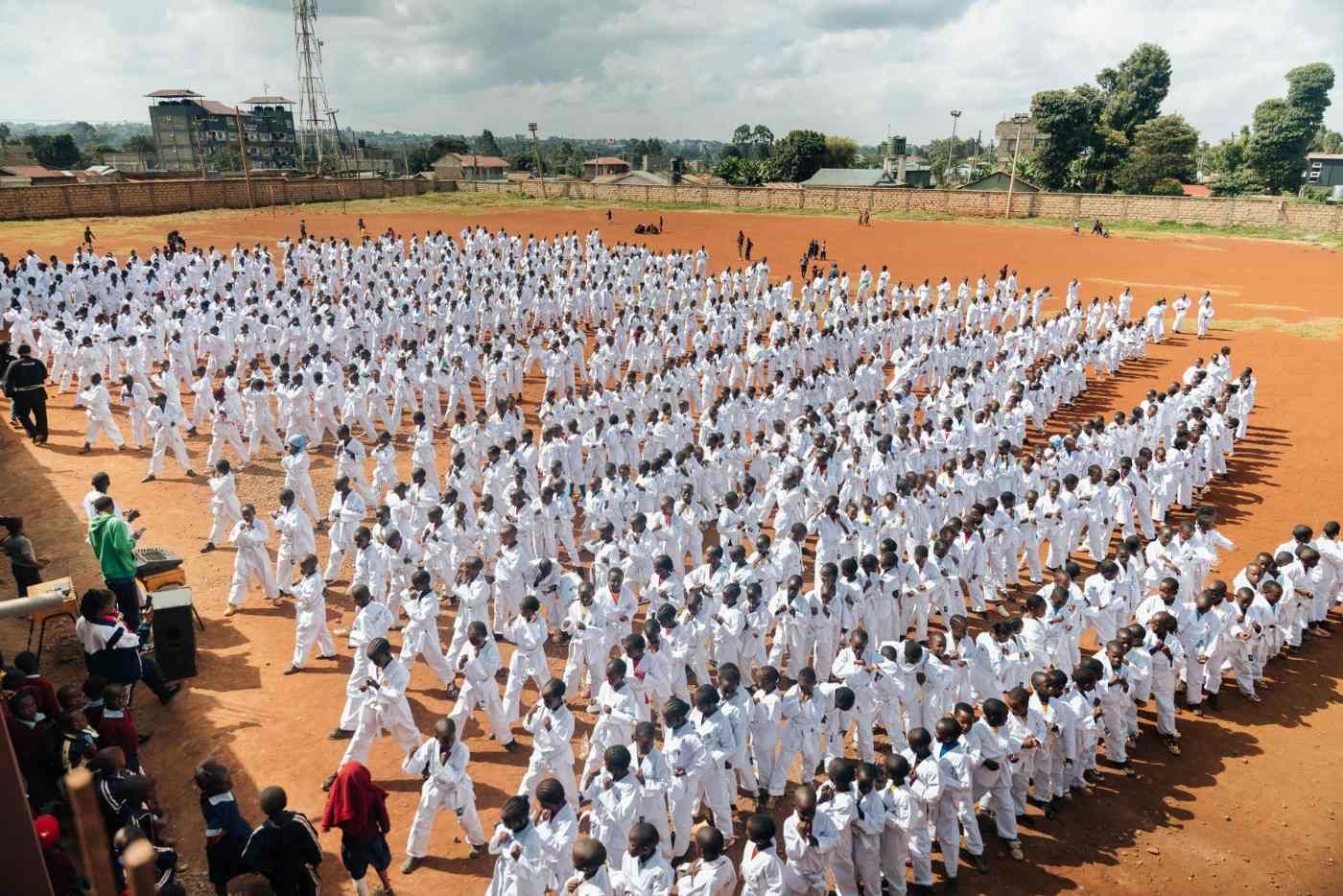 Around 1,000 children in white uniforms training together in one class in Kenya